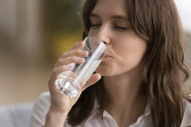 istock Thirsty young woman drinking clear natural cold water 1466489732