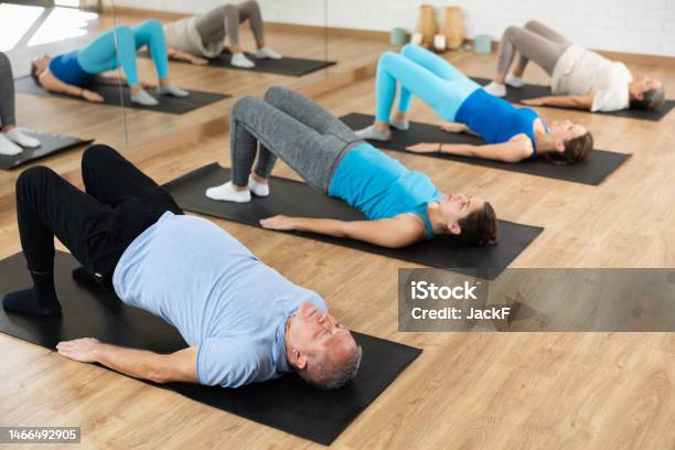 Aged Man Performing Glute Bridge In Fitness Studio Stock Photo - Download Image Now - Exercising, Sport, Stability