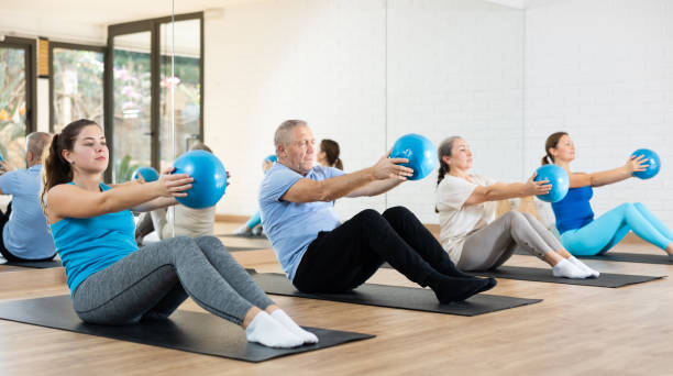 istock Young woman practicing pilates with ball in gym area 1466492982