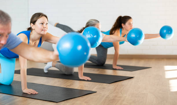 istock Middle-aged woman practicing pilates with ball in gym area 1466493004