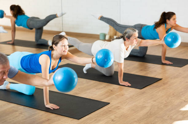 istock Middle-aged woman practicing pilates with ball in gym area 1466493015