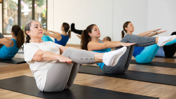 istock Senior woman doing v-sit during workout in fitness studio 1466494235