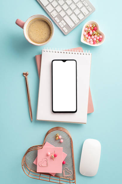 istock Top view vertical photo of smartphone notebooks pen keyboard computer mouse heart shaped stationery holders pushpins sticky note paper mug of coffee on isolated pastel blue background with copyspace 1466494658