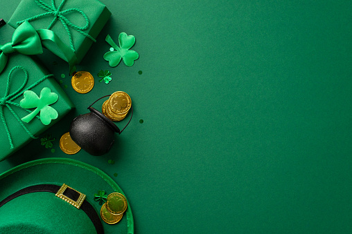 St Patrick's Day concept. Top view photo of leprechaun headwear gift boxes pot with gold coins bow-tie clovers and confetti on isolated green background with empty space