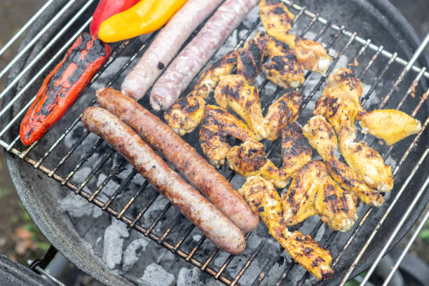 istock Fried sausages, chicken wings and grilled peppers. 1466510848