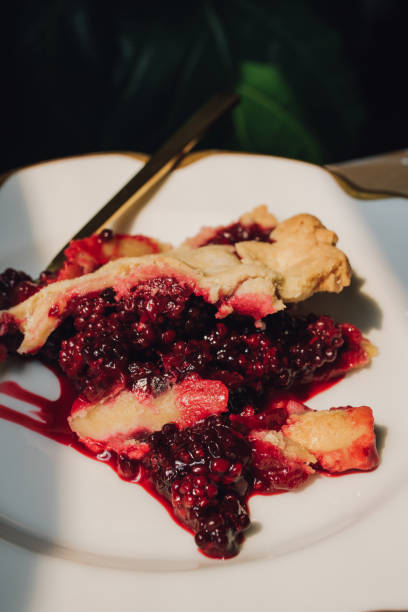 istock messy slice of blackberry pie on white plate 1466510850