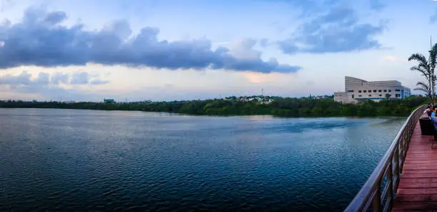 Panorámica de un lago en la hora azul, color naranja en el cielo, edificios en el fondo, laguna del carpintero en Tampico tamaulipas