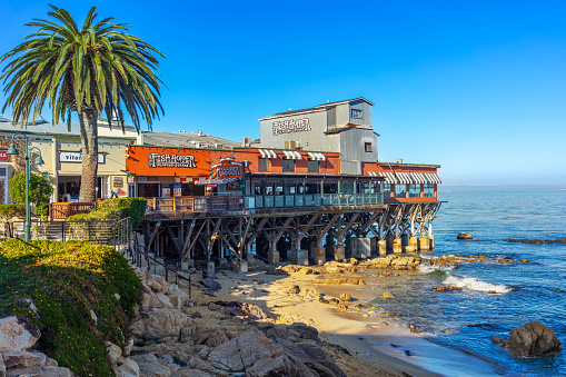 Monterey, CA, USA – December 16, 2022: Fish Hopper Restaurant on a pier and view of Monterey Bay in Monterey, California.