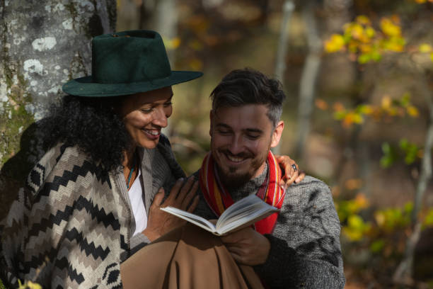istock A couple in love is sitting in the forest with a book. 1466527669