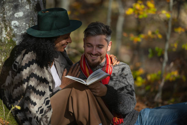 istock A couple in love is sitting in the forest with a book. 1466527675