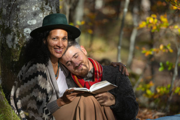 istock A couple in love is sitting in the forest with a book. 1466527677
