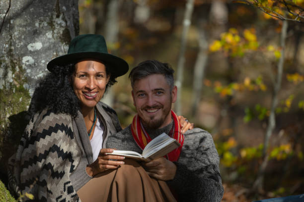 istock A couple in love is sitting in the forest with a book. 1466527682