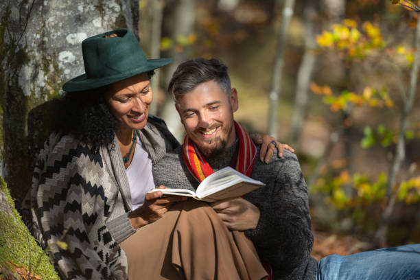 istock A couple in love is sitting in the forest with a book. 1466527687