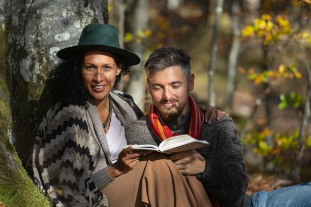 istock A couple in love is sitting in the forest with a book. 1466527688