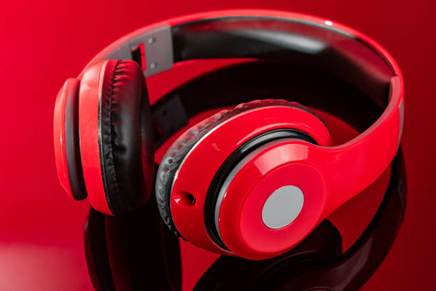 istock Red headphones lie on a mirrored red background 1466533309