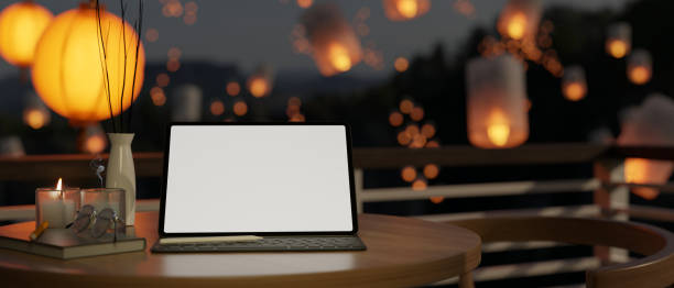 istock Workspace on the balcony with portable tablet mockup over blurred background of flying lanterns 1466533814