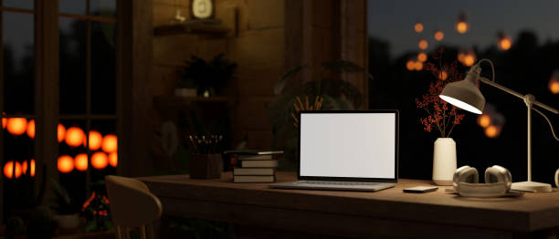 istock Comfortable and cozy home cottage at night with close-up workspace with laptop mockup 1466533864