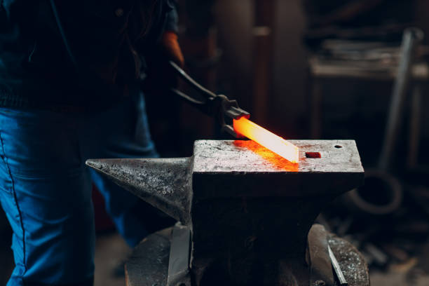 istock Blacksmith forges and makes metal detail with hammer and anvil at forge 1466540867