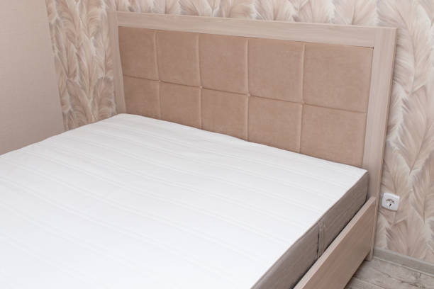 istock Beige soft modern bed with upholstered headboard in interior 1466547075