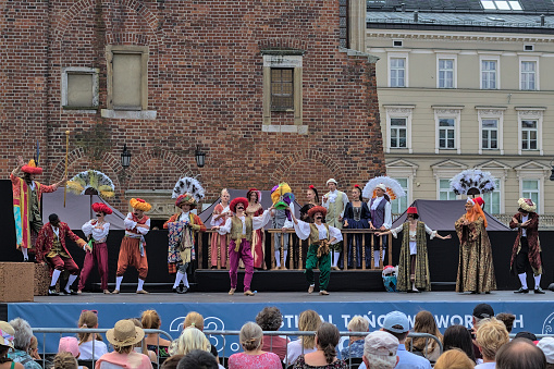 Krakow, Poland - July 24, 2022: Theatrical performance on the main square. Street Theater Festival. The performers perform in great costumes. Entrance to the performance is free.