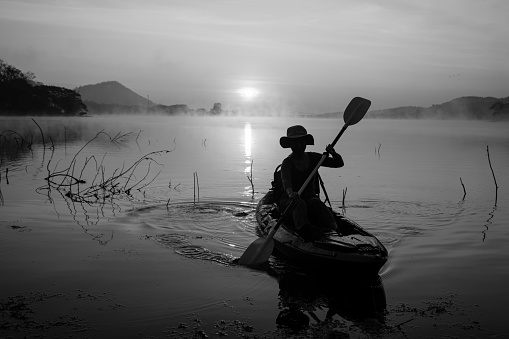 Women on kayak rows in the reservoir during the sunrise, Harirak forest park Huai Nam Man reservoir Loei Thailand 21 Jan 2023