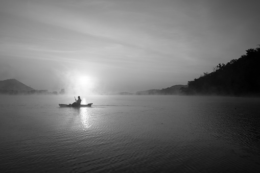 Women on kayak rows in the reservoir during the sunrise, Harirak forest park Huai Nam Man reservoir Loei Thailand 21 Jan 2023