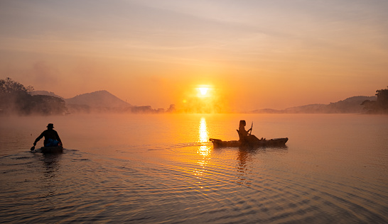 Women on kayak rows in the reservoir during the sunrise, Harirak forest park Huai Nam Man reservoir Loei Thailand 21 Jan 2023