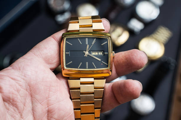 mano sosteniendo un reloj de pulsera de oro vintage, close up - calendar date pattern dial luxury fotografías e imágenes de stock