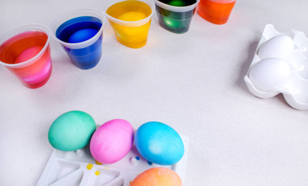 istock Tools for painting eggs for easter, eggs box, cups of colorful paint, easter eggs, plate, brushes and paints on the table side view 1466570195