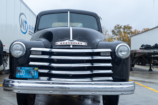 Lanus, Argentina – September 25, 2022: Lanus, Argentina - Sept 24, 2022: Old white 1940 Plymouth four door sedan in a park. Sunny day. Front view. Grille. AAA 2022 classic car show