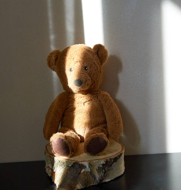 istock Toy brown bear on a stump in the sunlight. 1466574267