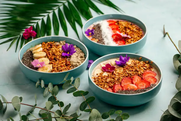 Photo of Different smoothie bowls with fruits and granola