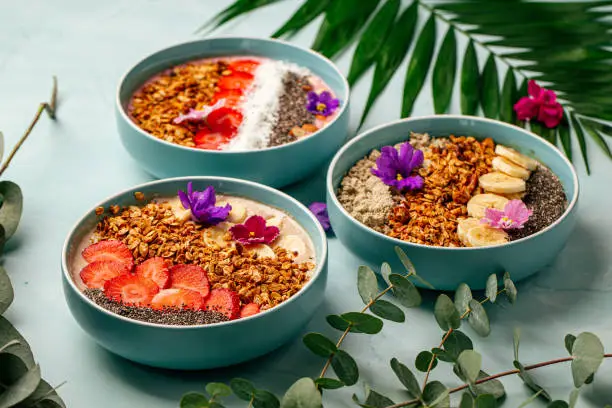Photo of Different smoothie bowls with fruits and granola