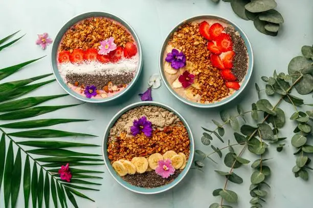 Photo of Different smoothie bowls with fruits and granola