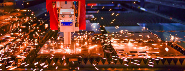 laser cut machine while cutting the sheet metal with the sparking light stock photo