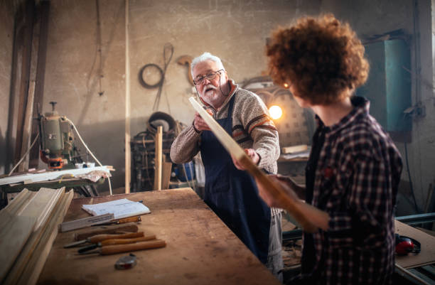 istock grandfather teaches grandson to work in carpentry workshop 1466587329