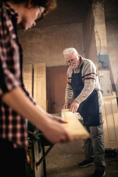 istock grandfather teaches grandson to work in carpentry workshop 1466587503