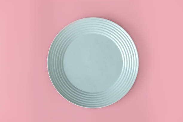 istock Top view of empty green plate on a pink background. Flat lay, copy space. 1466587740