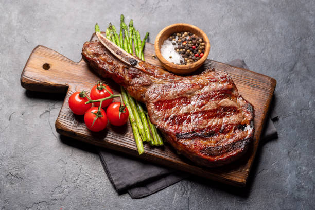 bife de carne tomahawk grelhado médio raro com aspargos - rib steak - fotografias e filmes do acervo
