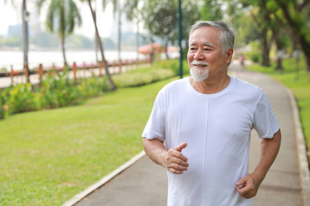 istock Happy and smiling asian senior man doing exercise and jogging or walking with relaxation for healthy in park outdoor after retirement during summer time. Health care elderly outdoor lifestyle concept. 1466594963