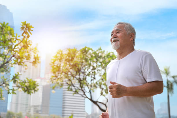 istock Happy and smiling asian senior man doing exercise and jogging or walking with relaxation for healthy in park outdoor after retirement during summer time. Health care elderly outdoor lifestyle concept. 1466594995