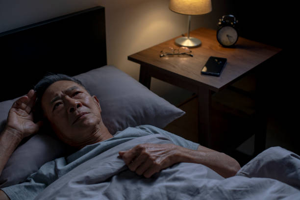 Depressed senior Asian man lying in bed cannot sleep from insomnia Depressed senior Asian man lying in bed cannot sleep from insomnia insomnia stock pictures, royalty-free photos & images