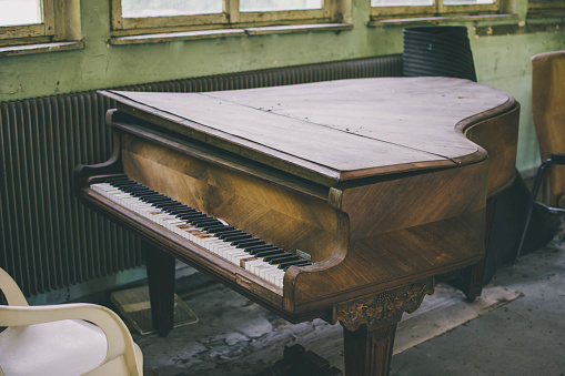 Old grand piano abandoned in a psychiatric hospital
