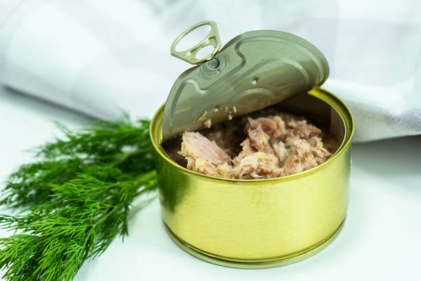 atún enlatado. atún enlatado de carne blanca albacora sin soja, envasado en agua. una lata de atún abierta sobre la mesa. filete de atún en conserva. una lata abierta de atún. enfoque selectivo. - can packaging tuna food fotografías e imágenes de stock