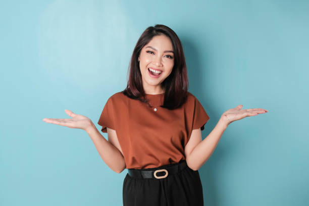 istock Smiling beautiful Asian woman pointing finger sideward to empty space isolated blue background 1466603073