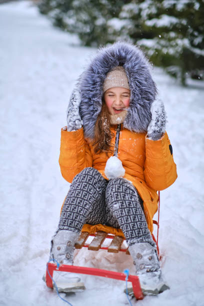 istock Child sledding, sits on a sled and throws snow. 1466609553