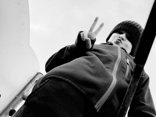 Charismatic young dancer, jumping up, looking at the camera. Black and white photo. Vertical view.