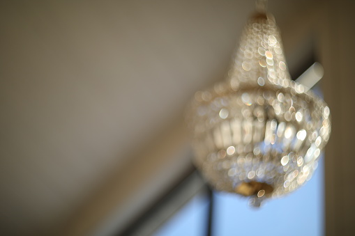 blurred crystal chandelier bokeh out of focus. Glamour background with copy space