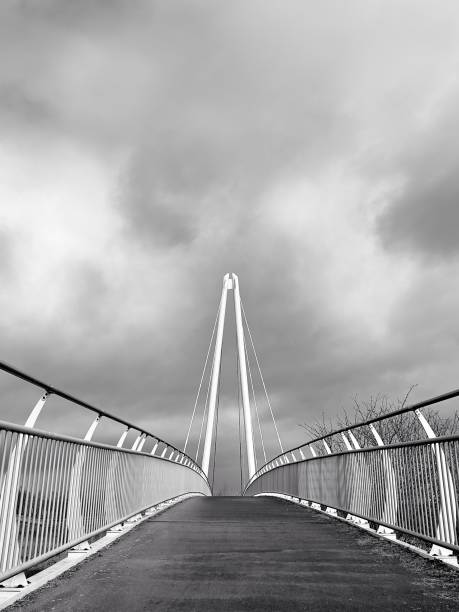 istock Moody sky over a pedestrian footbridge (black and white) 1466613557