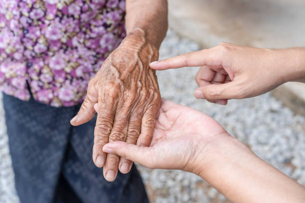 istock Daughter's fingers points to  wrinkled hand. Aging process - very old senior woman's hands wrinkled skin, effect of age on the skin, old age. wrinkled skin and prominent veins. elderly woman's hands 1466614187